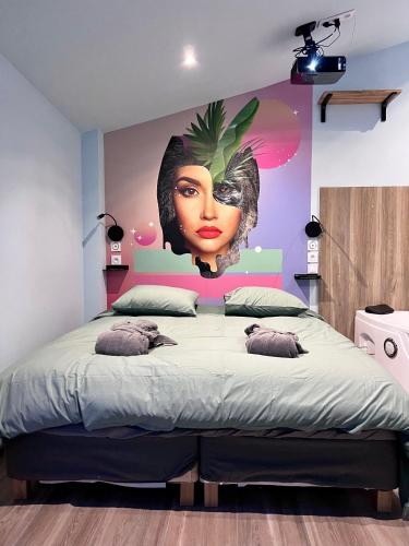 a bedroom with a bed with a painting of a woman at Capsule Safari - Jacuzzi - Nintendo Switch - Netflix & Home cinéma - Pouf géant - Filet suspendu in Douai