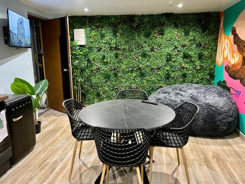 a table and chairs in a room with a green wall at Capsule Safari - Jacuzzi - Nintendo Switch - Netflix & Home cinéma - Pouf géant - Filet suspendu in Douai