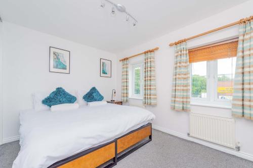 a bedroom with a bed and two windows at Central Townhouse Tipton - Sleeps 8 - Ideal for Contractors & Families in Tipton