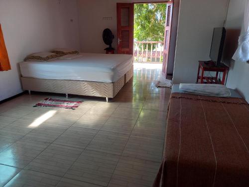 a bedroom with a bed and a tiled floor at Paracuru HolaOnda WaveHostel in Paracuru