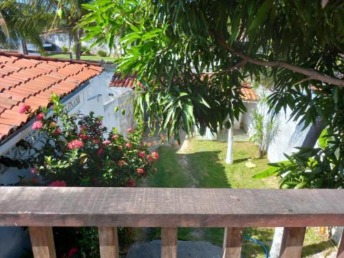 a wooden bench in front of a garden with flowers at Paracuru HolaOnda WaveHostel in Paracuru