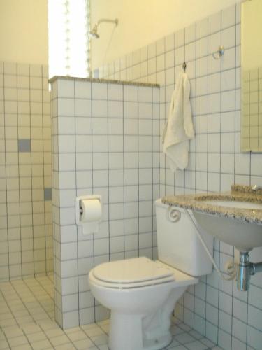 a bathroom with a white toilet and a sink at Pousada Baluarte in Salvador