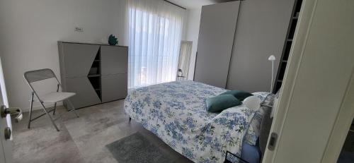 a bedroom with a bed and a dresser and a chair at IL SOGNO 1 Piscina e vista lago in Torri del Benaco