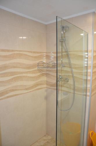 uma casa de banho com um chuveiro e uma porta de vidro em Orbi Palace Deluxe Bakuriani Room 406 em Bakuriani