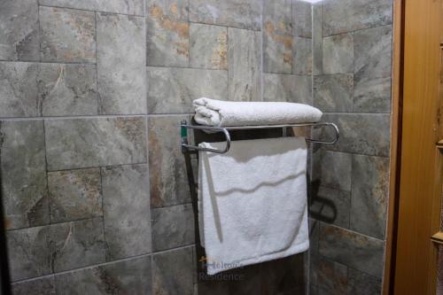 a towel rack in a bathroom with a shower at Helton´s Residence in Praia