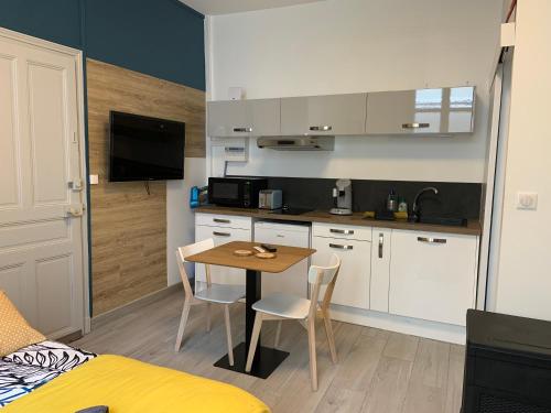 une cuisine avec une table et des chaises dans une pièce dans l'établissement arlequin, à Chinon