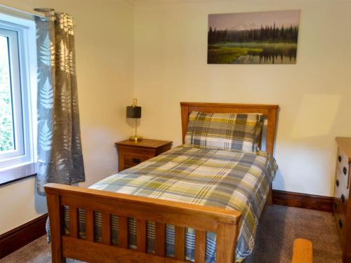 1 dormitorio con cama y ventana en Tree Tops Cottage, en Mundford