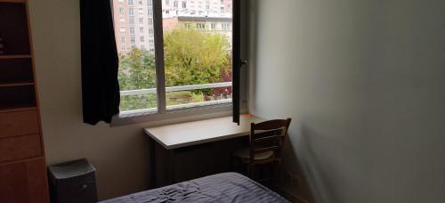 1 dormitorio con ventana, 1 cama y 1 silla en Chambre chez l'habitant a 5 minutes du métro en Ivry-sur-Seine