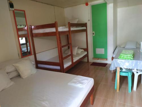 Zimmer mit 2 Etagenbetten und einem Tisch in der Unterkunft Emoks Guest House in Moalboal