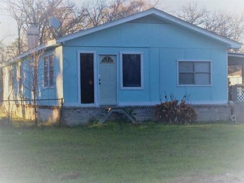 uma casa azul com uma porta da frente em Pretty Lakehouse for a Great, Inexpensive Getaway! em Livingston