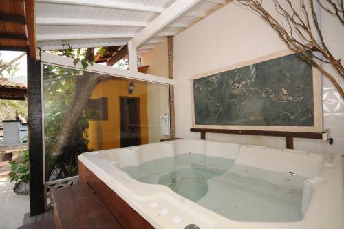 a large bath tub in a room with a painting at MANSION BOHEMIA in Búzios