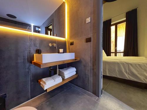 a bathroom with a sink and a mirror and a bed at Sant'Andrea - Luxury Rooms in Vucciria in Palermo