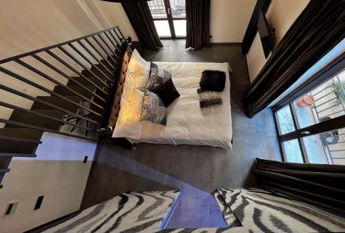 a living room with a couch and a staircase at Sant'Andrea - Luxury Rooms in Vucciria in Palermo