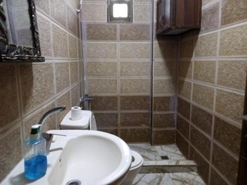a small bathroom with a sink and a toilet at Furnished apartment for rent in jarash شقة مفروشة للإيجار في جرش in Jerash