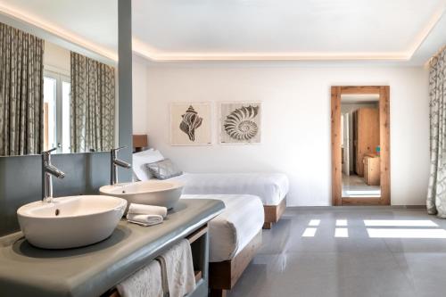 a hotel room with two sinks and a bed at Petinos Hotel in Platis Yialos Mykonos