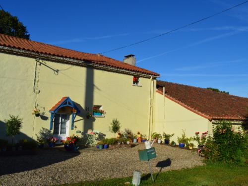 un edificio amarillo con un patio junto a una casa en Homestay Arrabella, en Availles-Limouzine