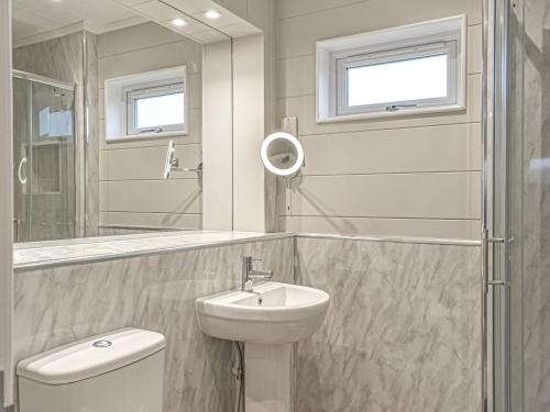 a bathroom with a sink and a toilet and a mirror at Whitey Top Country Lodge in Pentridge