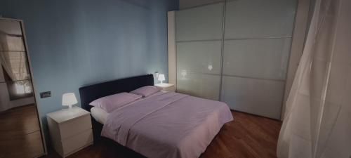 una camera da letto con un letto con lenzuola viola e uno specchio di crociali a Bologna