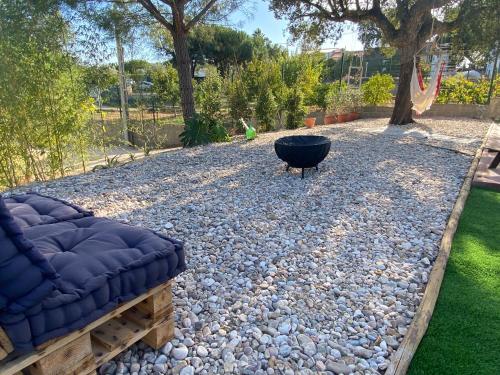 a fire pit sitting on a bed of rocks in a yard at Monte da Marouca-Mont’Argil in Montargil