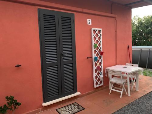 Casa roja con mesa y ventana en Camera graziosa, en Albinia