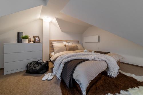 a bedroom with a bed with a blanket on it at Rákosárna Suites & Apartments in Špindlerův Mlýn