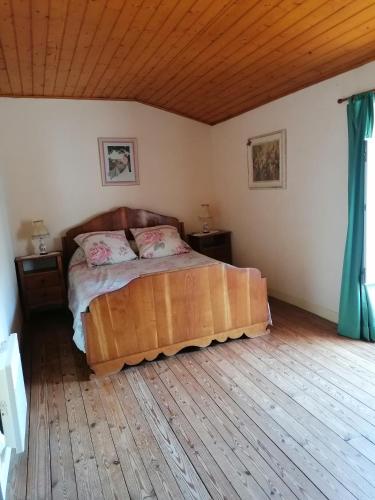 1 dormitorio con 1 cama y suelo de madera en Le 8, en Pouzauges