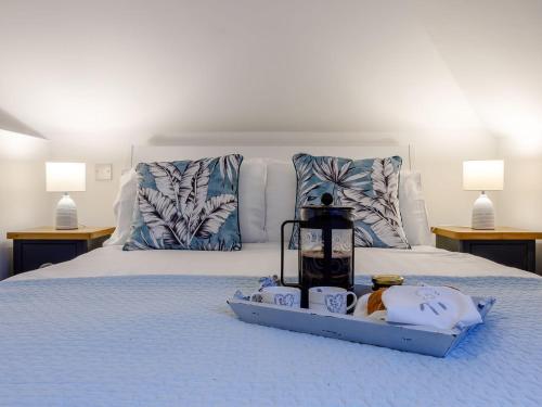 Una cama con una bandeja con toallas y una batidora. en Vineyards Apartment en Ely