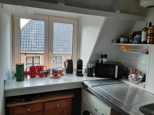 a kitchen counter with a microwave and a window at Logement het Herenwaltje in Leeuwarden