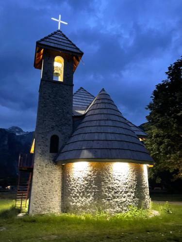 a church with a cross on top of it at Thethi view in Gjelaj