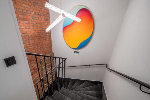 a staircase with a large painting on the wall at Rákosárna Suites & Apartments in Špindlerův Mlýn