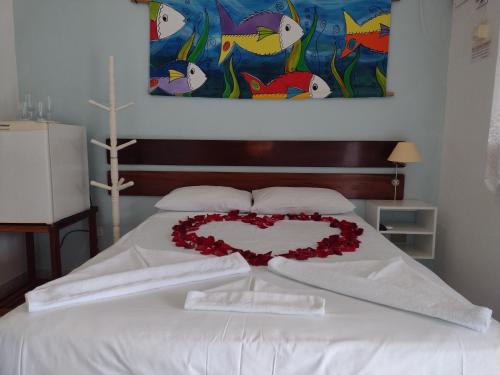 a bed with a heart made out of roses at Pousada do Rei in Ubatuba