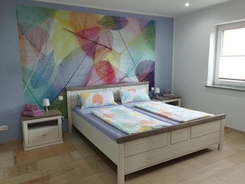 1 dormitorio con 1 cama con una pared colorida en RK Apartments Birnbaum en Gerhardshofen