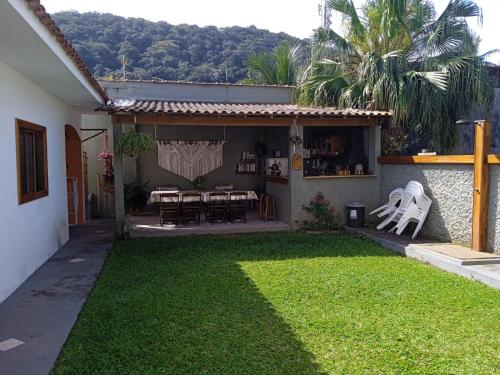 a house with a yard with a table and chairs at Terral Casa de Praia in Guarujá