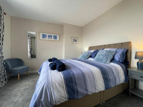 a bedroom with a bed and a blue chair at Harbour Street in Portmahomack