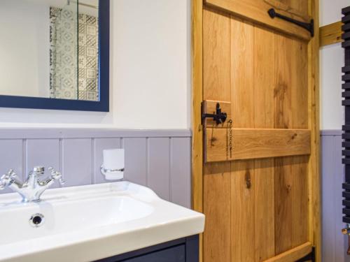 a bathroom with a sink and a wooden door at Middle Hanter - Uk37355 in Old Radnor