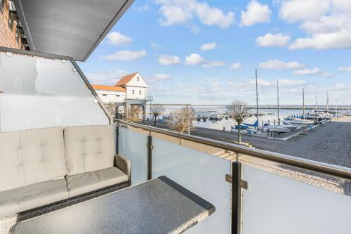 a balcony with a bench and a view of a marina at Lütt Haven in Barth