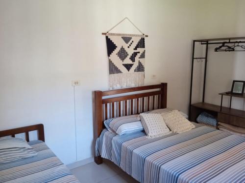 a bedroom with two beds and a quilt hanging on the wall at Terral Casa de Praia in Guarujá