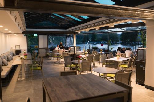 a restaurant with tables and chairs and people sitting at tables at Hotel Haus Burg Metternich in Beilstein