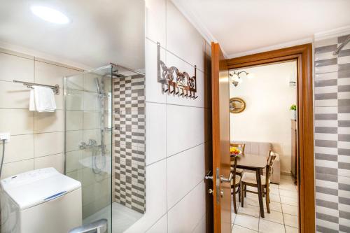 łazienka z prysznicem, toaletą i stołem w obiekcie Rikki Apartment w Korfu