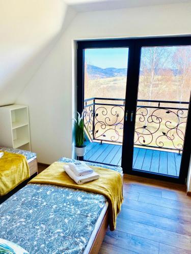 a room with two beds and a balcony at Osada Żywiec in Żywiec