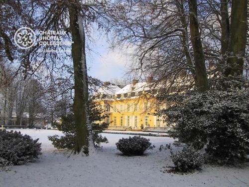 a large yellow building with snow on the ground at Château de Sissi in Sassetot-le-Mauconduit