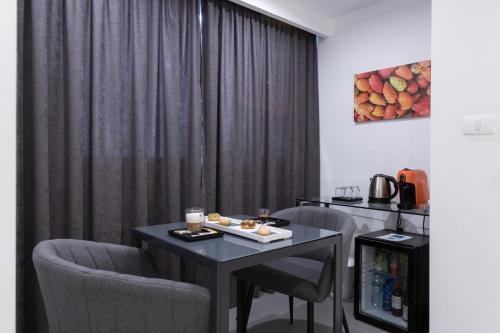 パレルモにあるSuite Palermo Apartmentのテーブルと椅子、カーテンが備わる客室です。