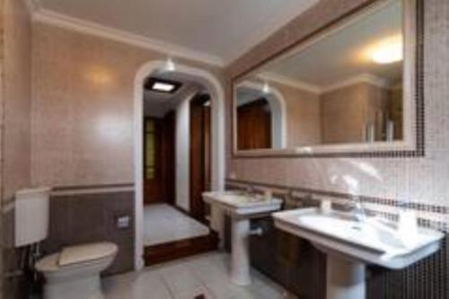 y baño con 2 lavabos, aseo y espejo. en Timanfaya Villa, en Tahiche