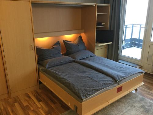 ein Schlafzimmer mit einem großen Bett mit blauen Kissen in der Unterkunft FERIENWOHNUNG FORSTPANORAMA in Sankt Englmar