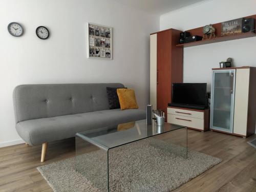 uma sala de estar com um sofá e uma mesa de vidro em Spacious apartment in hip neighborhood em Budapeste