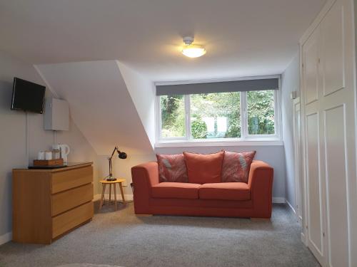 sala de estar con sofá rojo y ventana en Carnaburg Guesthouse, en Tobermory