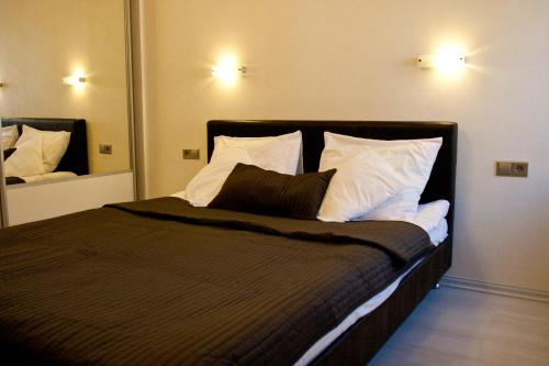 1 dormitorio con 1 cama grande y 2 espejos en Nice & Cheap Apartment and FREE parking, en Riga