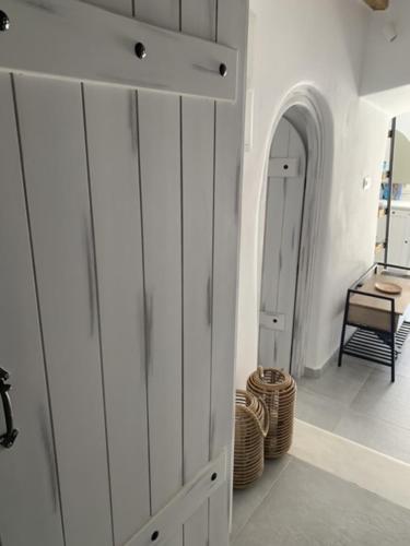 a room with white cabinets and a hallway with a chair at Serenity Living Platia, Tinos in Platiá