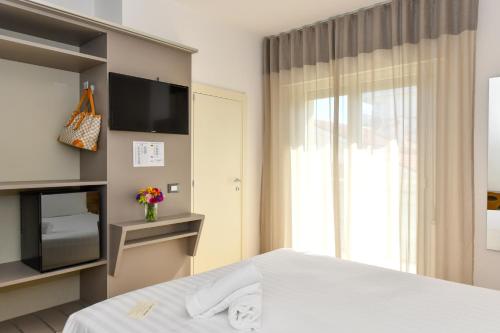 a hotel room with a bed and a television at Hotel Delle Mimose in Lido di Jesolo