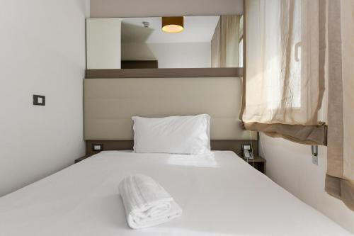 a bedroom with a bed with a towel on it at Hotel Delle Mimose in Lido di Jesolo